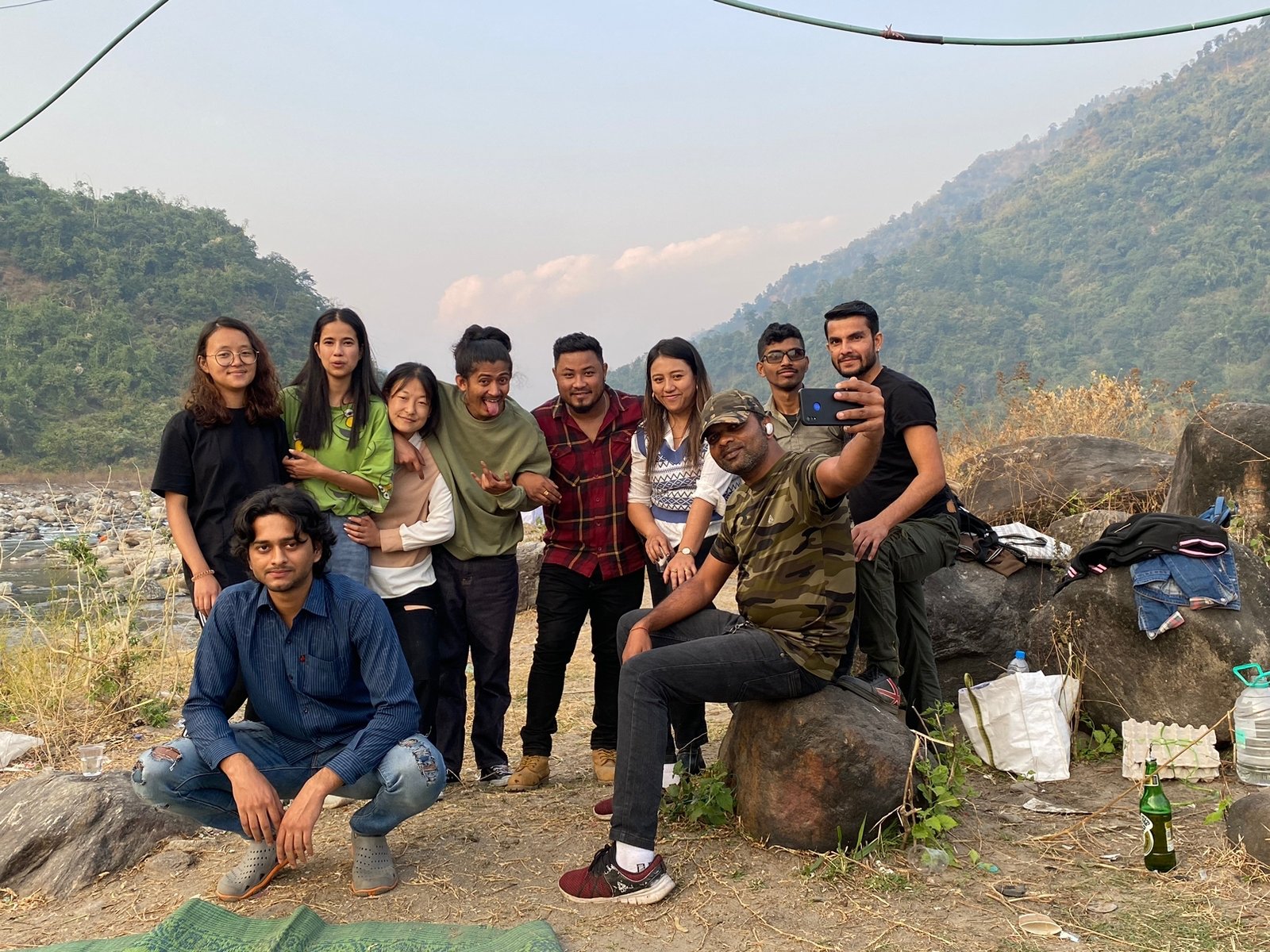 Student group relaxing on the rocks by the Teesta river