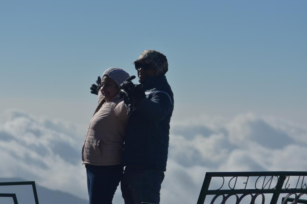 Honeymoon couple watching the clouds from a Mirik viewpoint